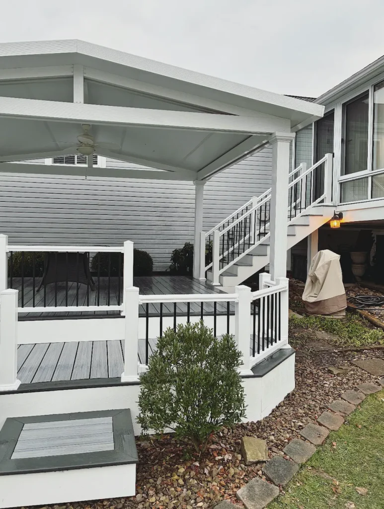Covered deck and porch installation with white railing and stairs in Pittsburgh PA residential backyard