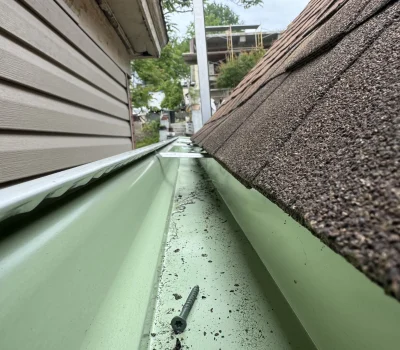 Seamless gutter system installed to ensure efficient water flow and long-term drainage performance Seamless gutter installation with clean interior drainage channel on residential roof in Pittsburgh PA
