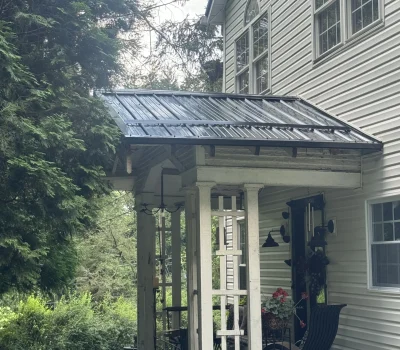 Durable metal roofing installed over front porch for enhanced weather resistance and modern appearance. Metal roof installation on front porch structure in Pittsburgh PA residential home