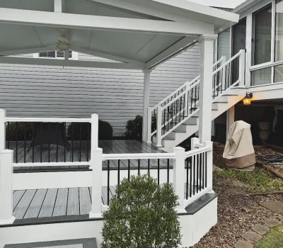 Custom covered deck designed for comfort, functionality, and enhanced outdoor living space. Covered deck and porch installation with white railing and stairs in Pittsburgh PA residential backyard