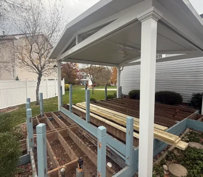 Structural framing for covered porch installation, setting the foundation for a durable outdoor structure. Covered porch framing construction in progress with posts and roof structure in Pittsburgh PA